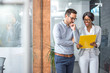 © Bojan - Concentrated man and woman examining business plan while standing in office