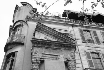 Sightseeing in Arles, Provence, France. A building with Roman portico and columns at Forum square. Black white historic photo.