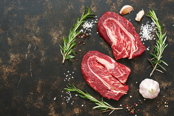 Raw marbled beef meat with spices close-up. A fresh top of the beef. A view from above, a copy of the space.