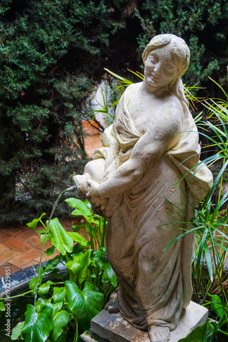 Fotografía escultura de mujer en la fuente del jardín