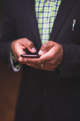 African american man in black suit using mobile device