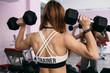 © kristina_1994 - Fitness girl works with dumbbells in front of the mirror in the gym