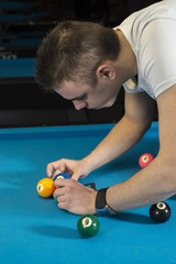 Wall Mural - A billiard player assembling a rack of 9 ball on a professional pool table.