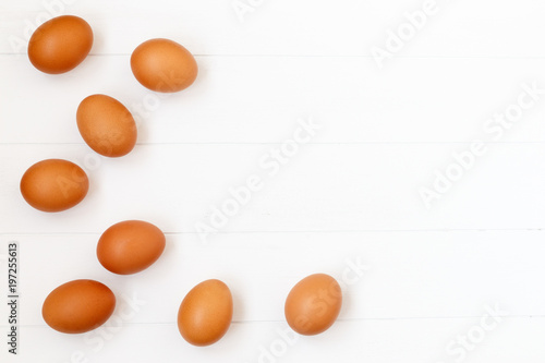 Fotografía fresh or raw brown eggs on white wooden background, top view, flat lay with copy