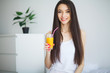 © Maksymiv Iurii - Casual smiling woman holding a glass of orange juice