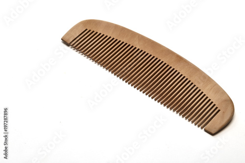 Fotografía closeup brown wooden comb on a white background