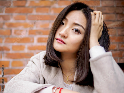 Fotografie, Obraz Closeup fashion beautiful Chinese woman portrait with long hair looking at camera expressionless, focus on eyes