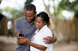 © vystekimages - smiling couple with mobile phone outside