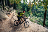 Fototapeta  - Mountain biker riding cycling in autumn forest