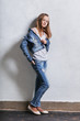 © Valendina - Fashion teenager girl standing leaning back against a white concrete wall. Young caucasian woman 11-14 years in casual stylish clothes, denim jacket, white singlet cotton, youth jeans.