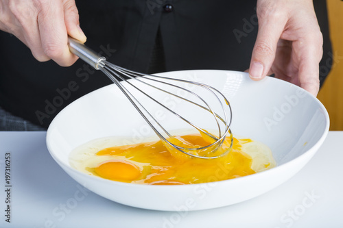 Zdjęcie XXL Szef kuchni bije jajko z trzepaczki