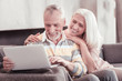 © Viacheslav Yakobchuk - Funny moments. Interested aged pleasant couple spending time together at home smiling and working with the laptop.