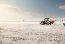 Farmer With Tractor Seeding - Sowing Crops At Agricultural Fields In Winter