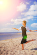 © raisondtre - Portrait young slim pretty woman in black dress, jumping barefoot on sand the seashore, a background of blue sky and white clouds air.