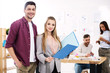 © LIGHTFIELD STUDIOS - selective focus of business people with folder and multiethnic colleagues behind in office