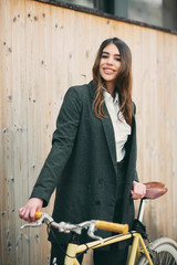 Wall Mural - Woman walking down the street and holding the bicycle.