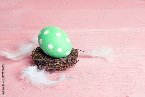 Zdjęcie XXL Wielkanocny jajko w gniazdeczku na różowym stole.