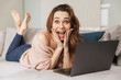 © Drobot Dean - Portrait of a joyful young woman using laptop computer