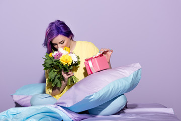 Wall Mural - beautiful young woman with gift box and flowers sitting in bed