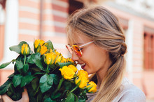 Cute Girl Sniffs Yellow Roses
