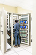 © BBandSIRI - Electrician working with a screwdriver or multimeter for installation, connecting, checking, wiring and fix the electrical equipment on the electrical panel in the control room, power plant.