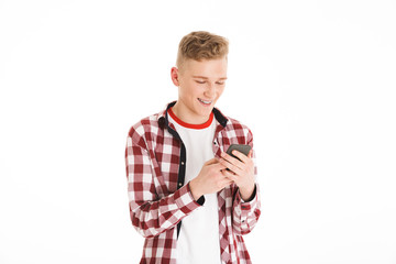 Poster - Caucasian teenager in casual t-shirt 17y wearing braces holding cell phone and looking at screen while browsing or typing, isolated over white background