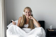 © AnastazjaSoroka - Happy morning. Young woman listen music in white bed.