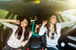 © F8  \ Suport Ukraine - Three young beauty girls driving in a car dancing and having fun in city street