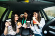 Beautiful stylish girls are making selfie eating fast food and having fun while sitting in the car