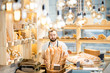 © rh2010 - Handsome bread seller with basket full of baguettes in the beautiful store with bakery products