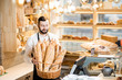 © rh2010 - Handsome bread seller with basket full of baguettes in the beautiful store with bakery products