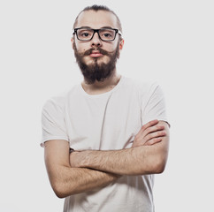 Lifestyle and people concept: Young bearded guy crossing his arms over white background