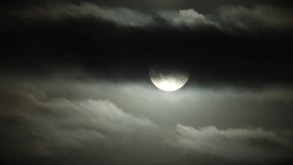 Wall Mural - dark clouds fill night sky with full moon rising at night, time lapse.