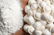 © Africa Studio - Raw dumplings and flour on wooden table