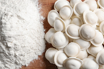 Wall Mural - Raw dumplings and flour on wooden table