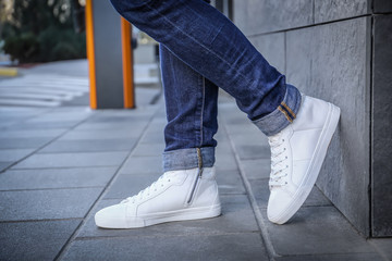 Stylish man in white shoes on city street