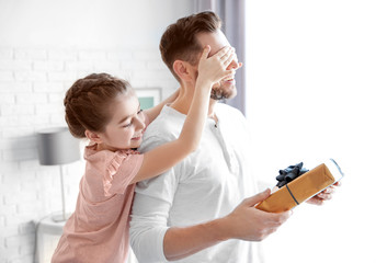 Wall Mural - Man receiving gift for Father's Day from his daughter at home