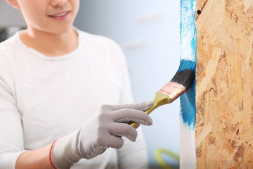 Poster - Male decorator painting wall with brush indoors