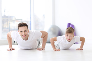 Canvas Print - Dad and his son training in gym