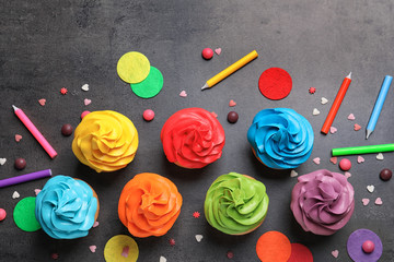 Delicious birthday cupcakes on gray background