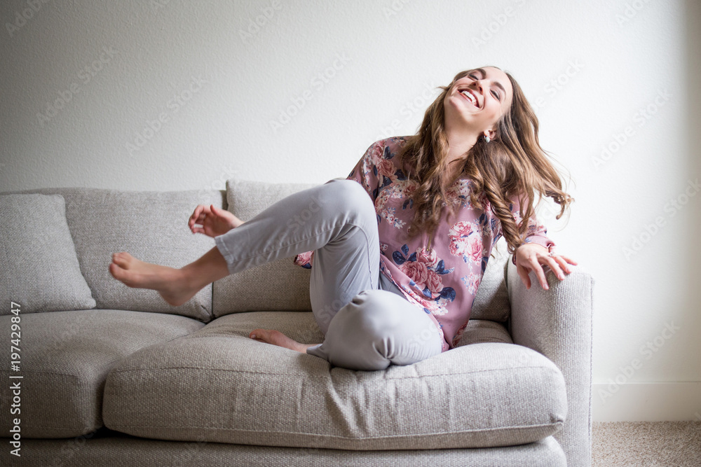 Happy young woman relaxing at home on couch Stock Photo | Adobe Stock