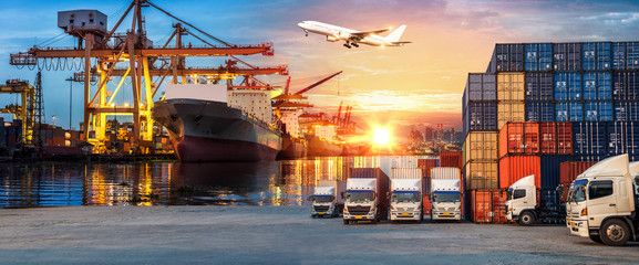 Logistics and transportation of Container Cargo ship and Cargo plane with working crane bridge in shipyard at sunrise, logistic import export and transport industry background