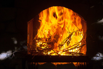 A bright and hot flame in the opening of the fireplace.