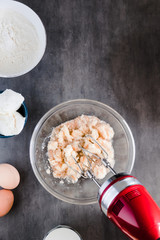 Wall Mural - Mixing baking ingredients in a bowl for cake or pancakes. Minimal dark food photography styling concept. Vertical, flat lay