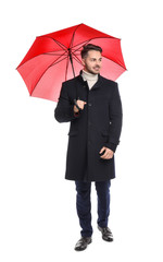 Poster - Young man in warm coat with red umbrella on white background