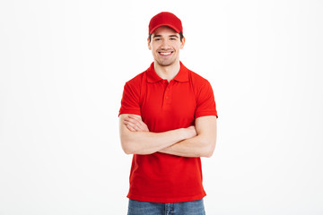 Smiling young delivery man in red cap