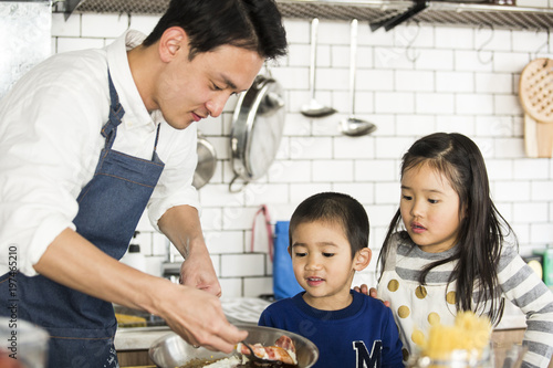 ベーコンエッグを作っているお父さん 料理上手 息子と娘は心配そうに眺めている Stock Photo Adobe Stock
