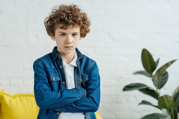 Serious child standing with arms folded