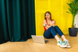 © dmshpak - Attractive stylish girl with a laptop on a background of yellow wall.