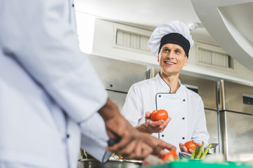 Wall Mural - multicultural chefs preparing salad at restaurant kitchen